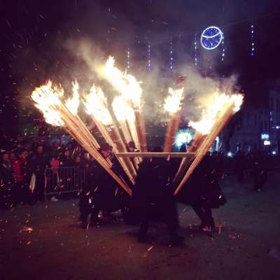 Dozens of torches carried by men dressed in traditional costumes
